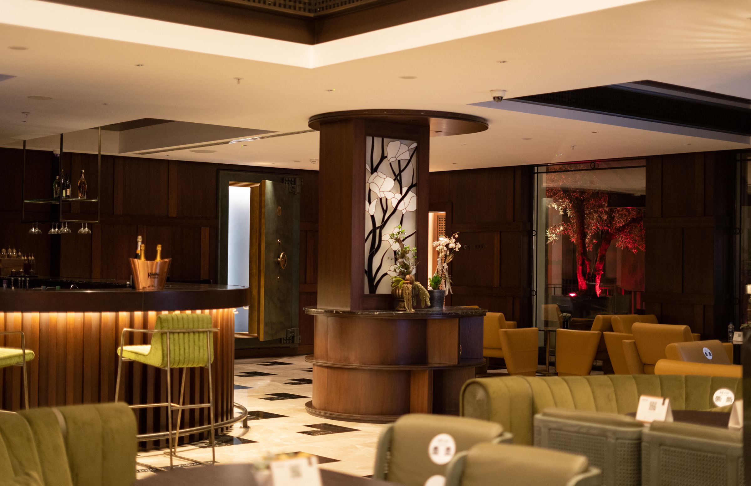 Lobby-bar de hotel com luz quente e materiais naturais